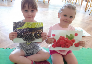 Dziewczynki pokazują obrazki owoców